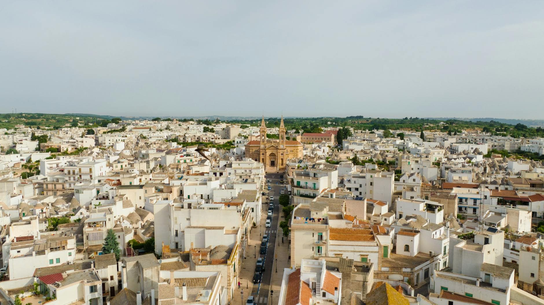 Aerial view of a historic town with a prominent church and traditional architecture seen from above.