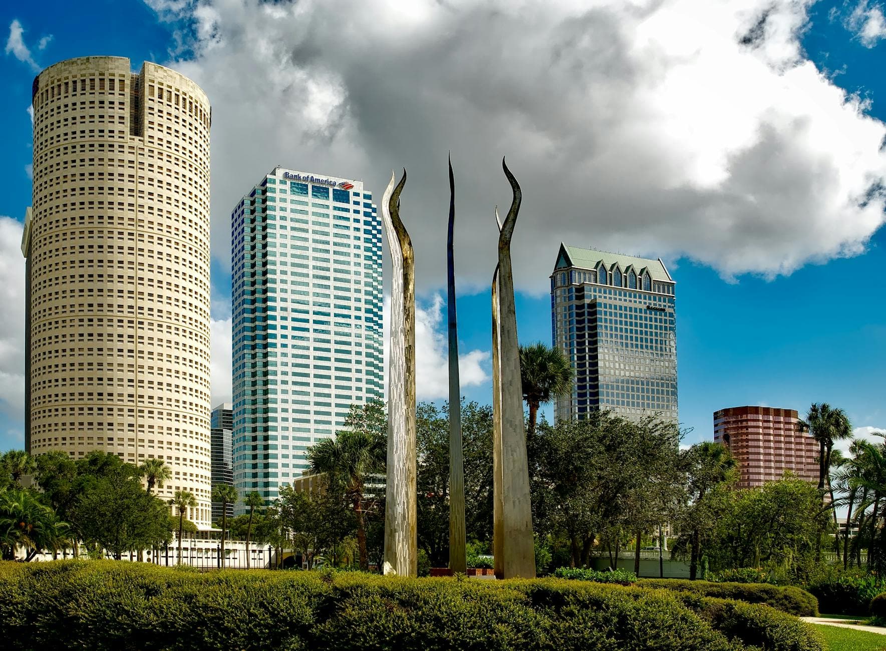 Tampa's skyline features tall skyscrapers and modern sculptures under a bright sky.