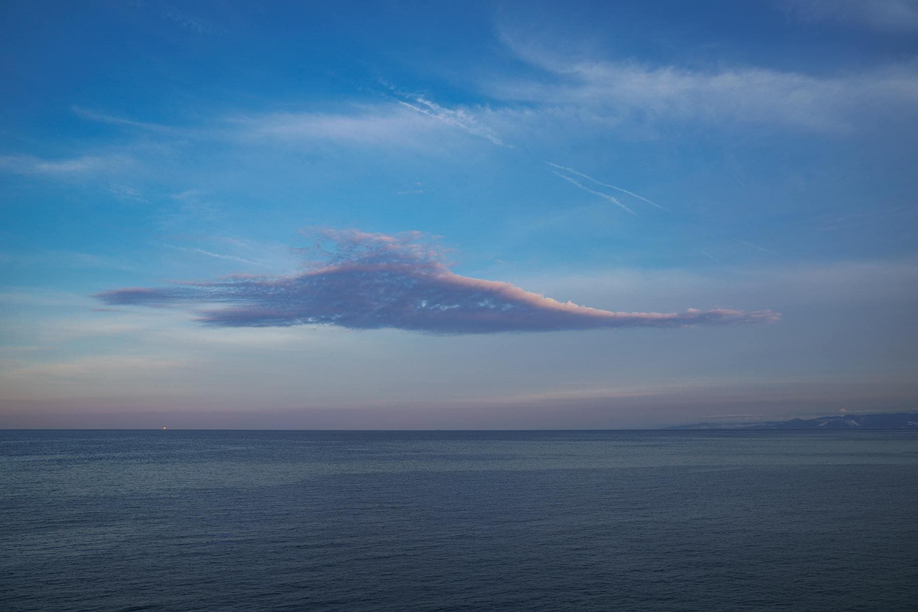 Tranquil view of a pink cloud above the calm sea near Tekirdağ, Türkiye at twilight.