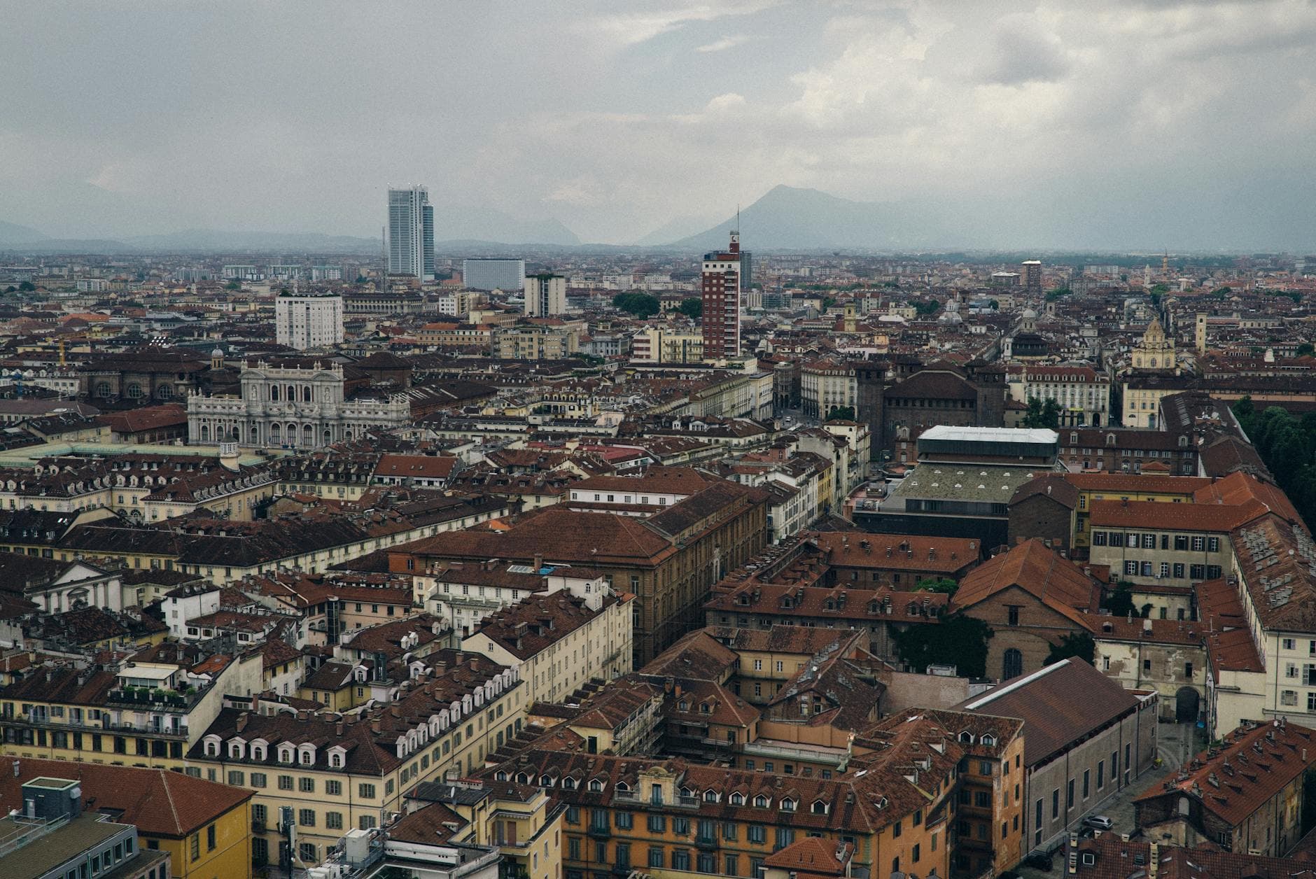 Explore the expansive skyline of Turin, Italy, showcasing its historic architecture set against distant mountains.