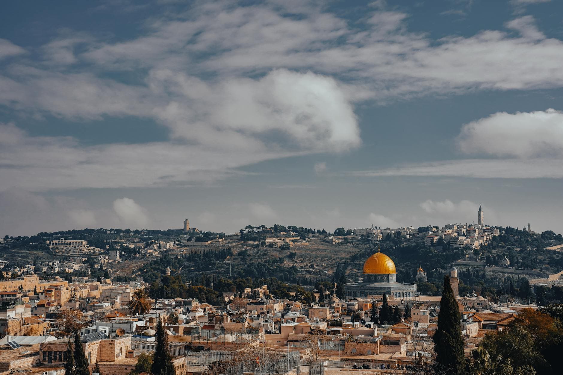 Stunning aerial view of Jerusalem cityscape with iconic Dome of the Rock amidst historical landmarks.