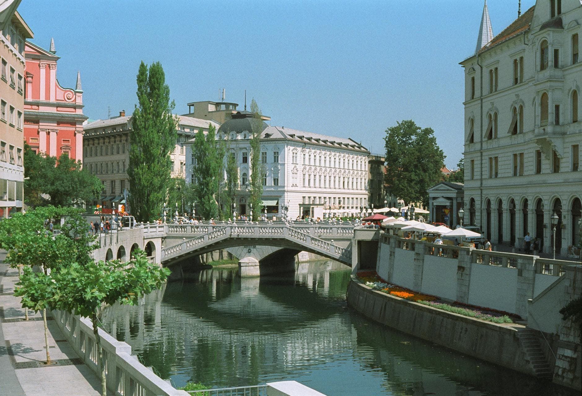 Scenic view of the Triple Bridge and Ljubljanica River with historic architecture in Ljubljana, Slovenia.
