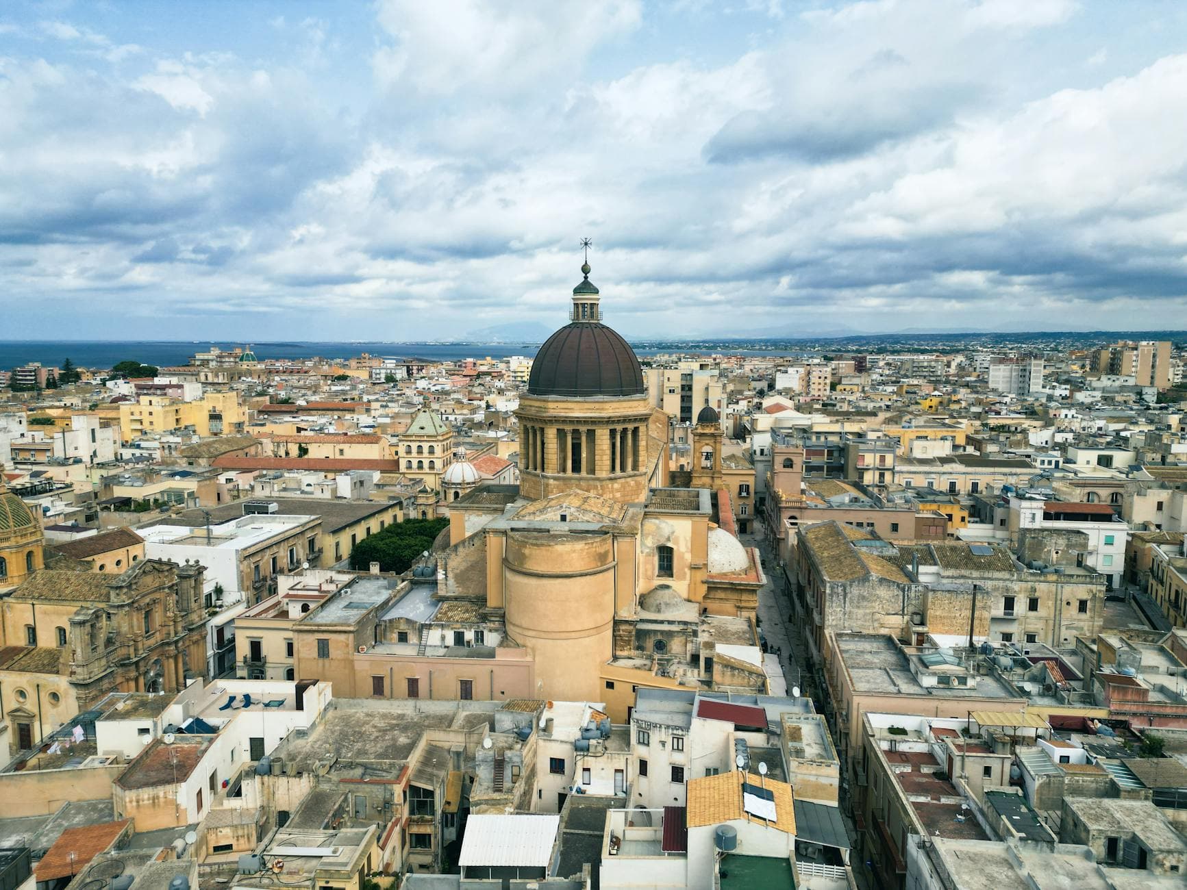 Aerial cityscape of Marsala, Italy showcasing historic architecture and church dome.