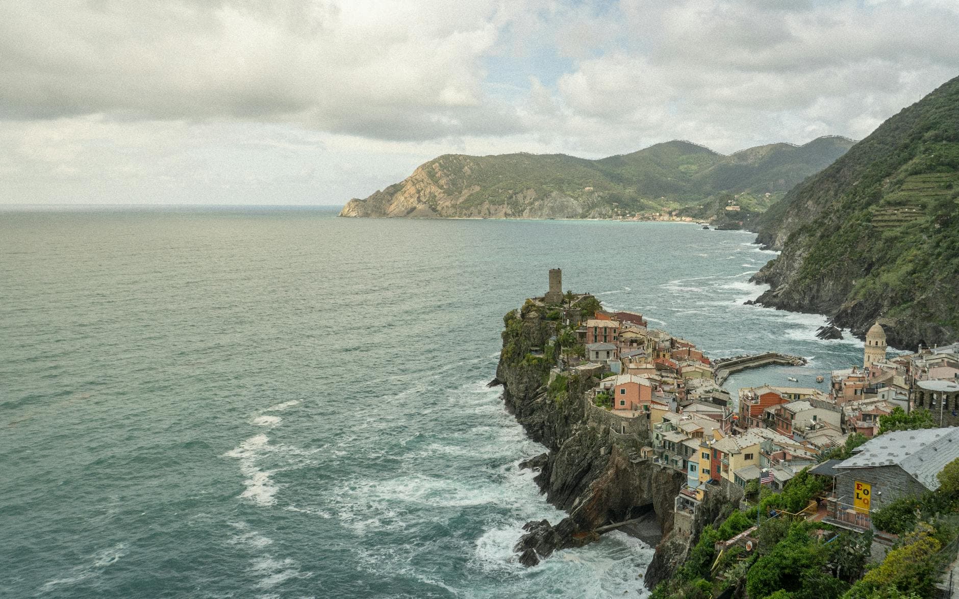 Aerial view of Vernazza, a coastal village in Cinque Terre, Italy, featuring colorful houses and ocean.