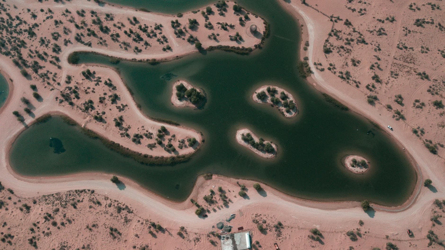A striking aerial view showcasing the natural lakes surrounded by desert landscape in Dubai, UAE.
