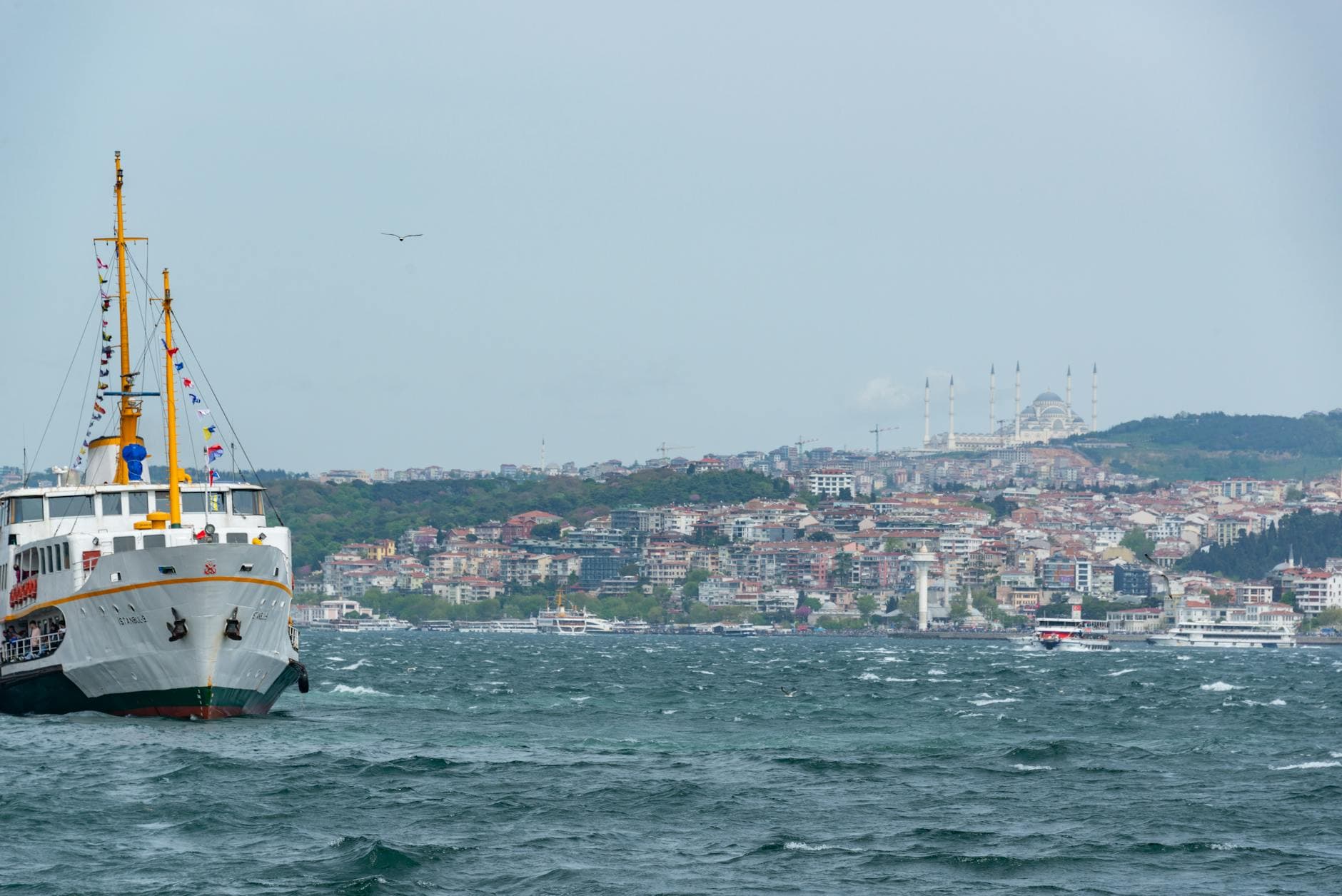 Scenic ferry journey on Bosphorus with view of Istanbul's historic skyline and mosque.