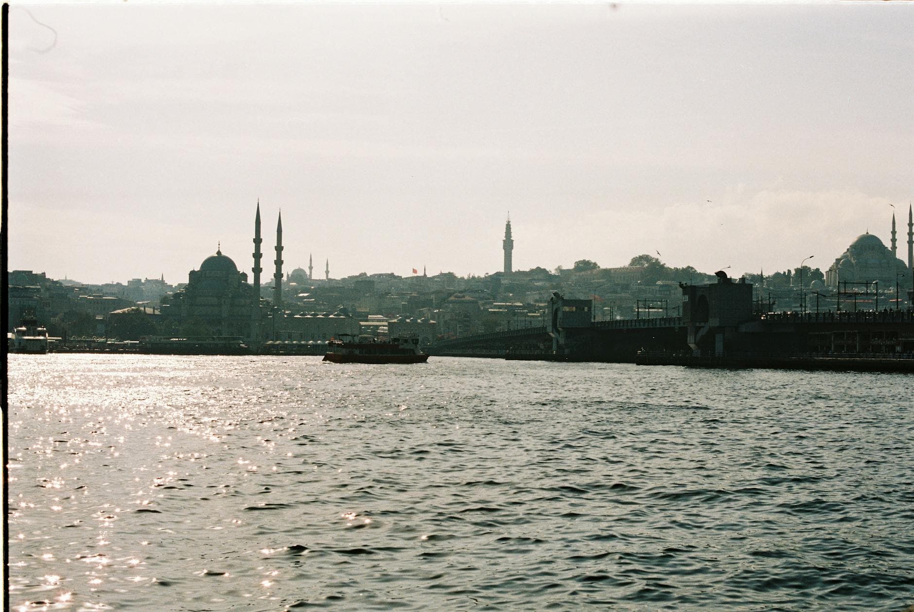 Scenic view of Istanbul's skyline at sunset, featuring Galata Bridge and iconic mosques.