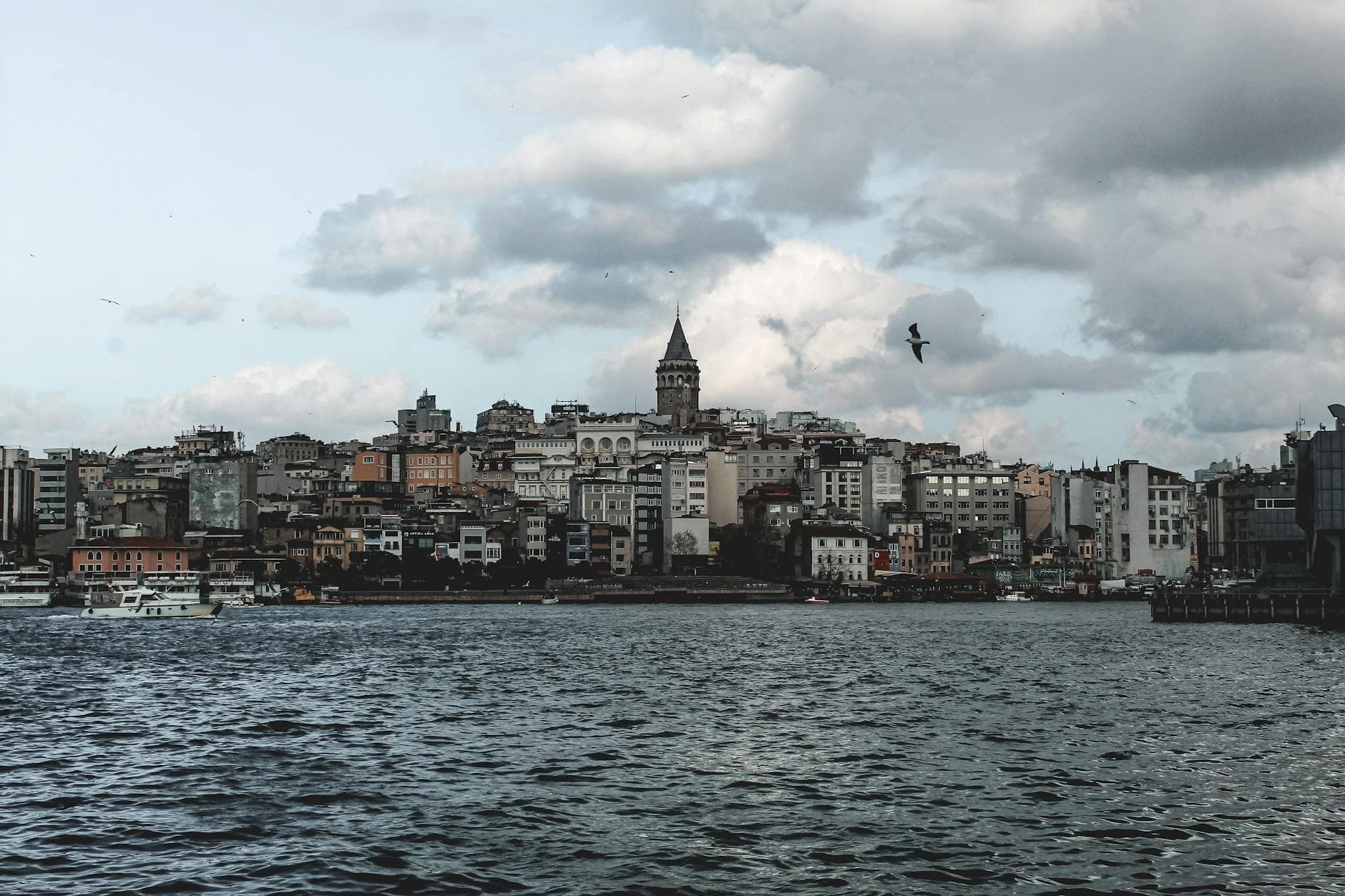 Beautiful view of Galata Tower amidst Istanbul skyline with waterfront and clouds.