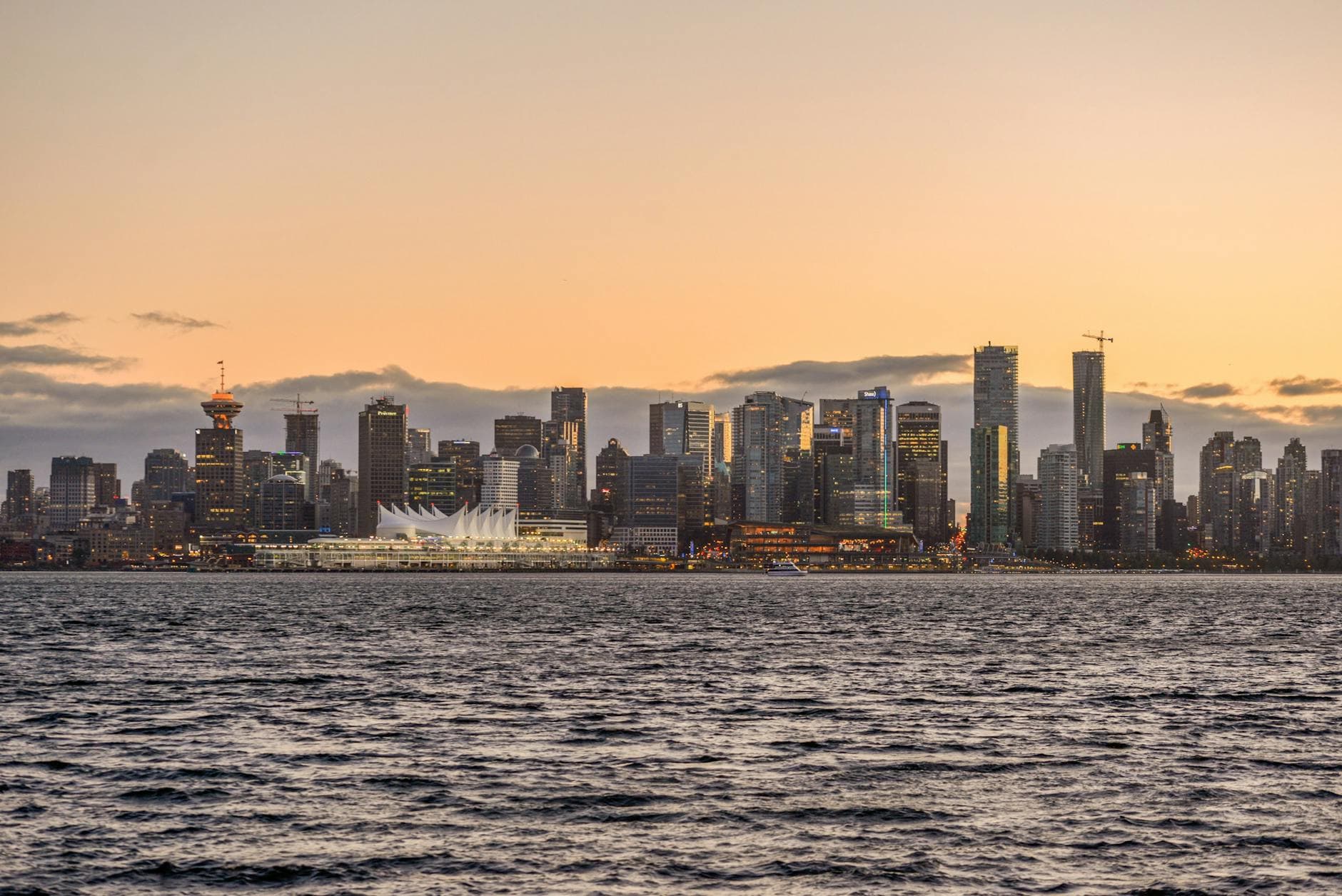 Stunning view of Vancouver's downtown skyline with waterfront and sunset glow.