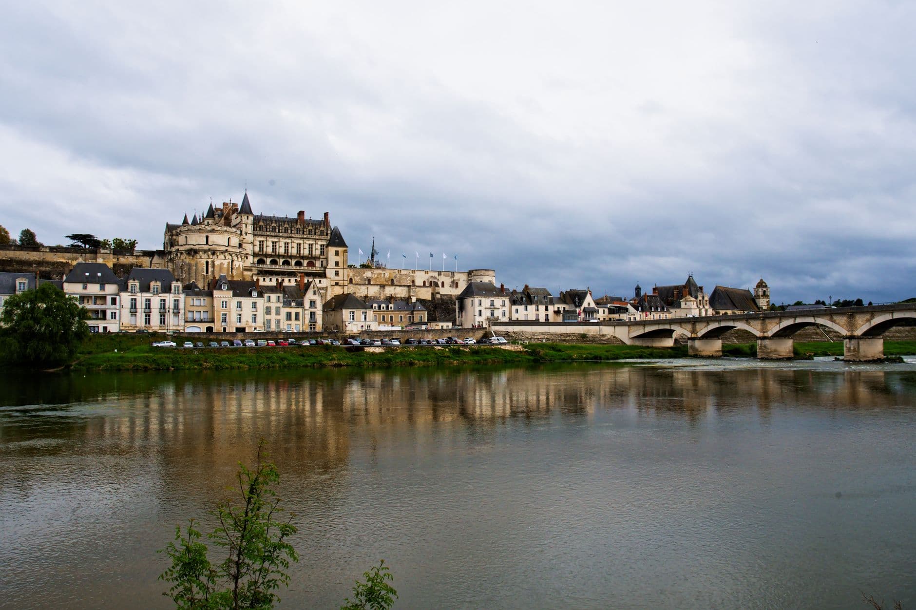 Scenic view of Château d'Amboise over the Loire River in France with a historic bridge.