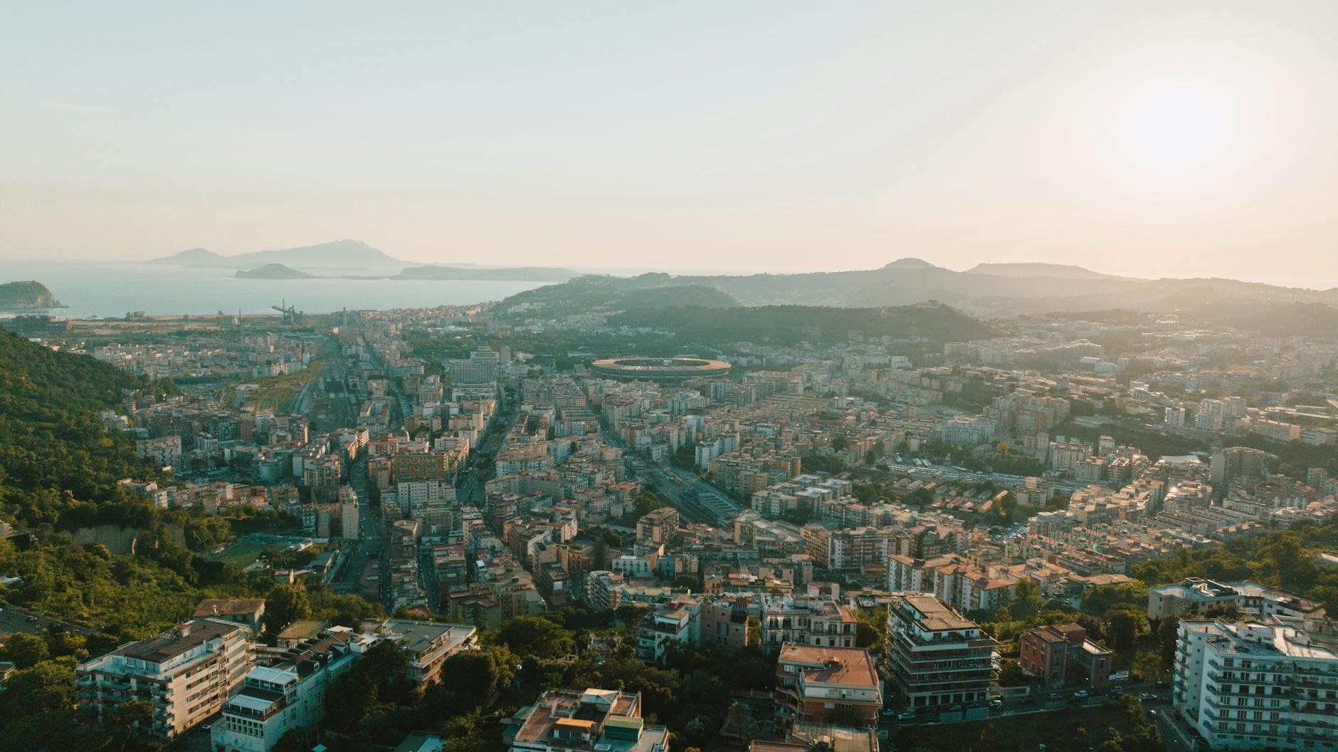 Stunning aerial view of a coastal city under a warm sunset glow.