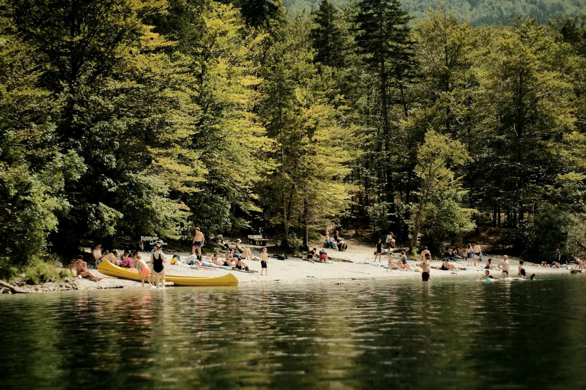 Relaxing summer scene at Soča River with people enjoying the sunny beach.