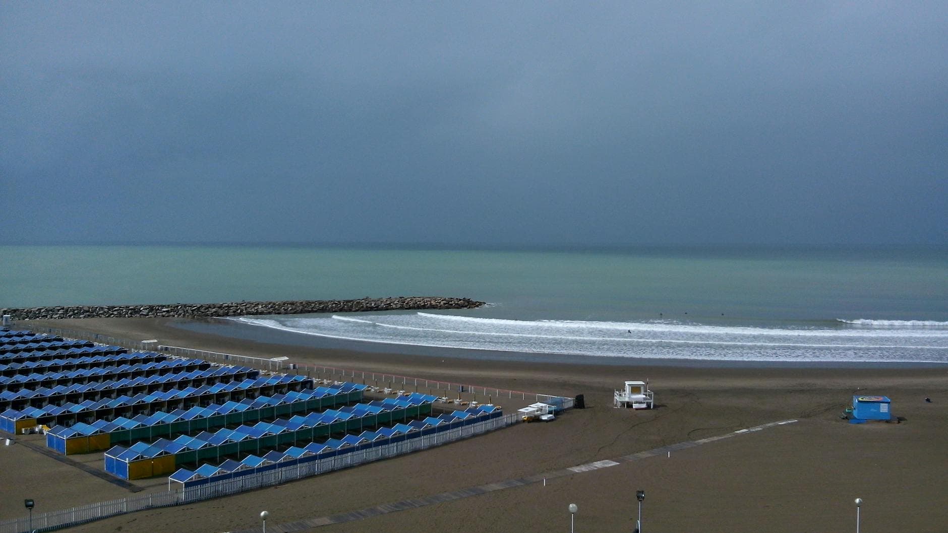 Aerial view of Mar del Plata beach with colorful huts and overcast skies in Argentina.