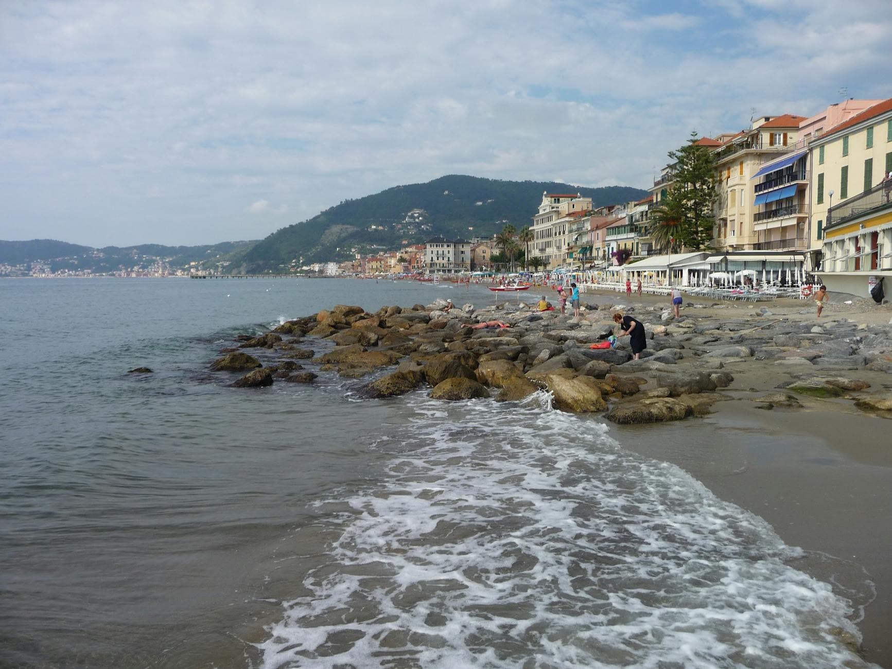 Picturesque coastline with rocky shore and vibrant town in the background.