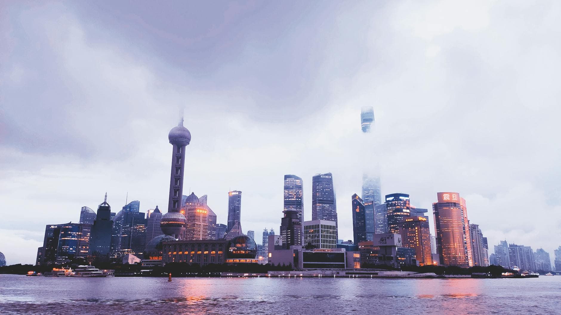 A stunning view of Shanghai's skyline at twilight showcasing modern architecture and skyscrapers along the waterfront.