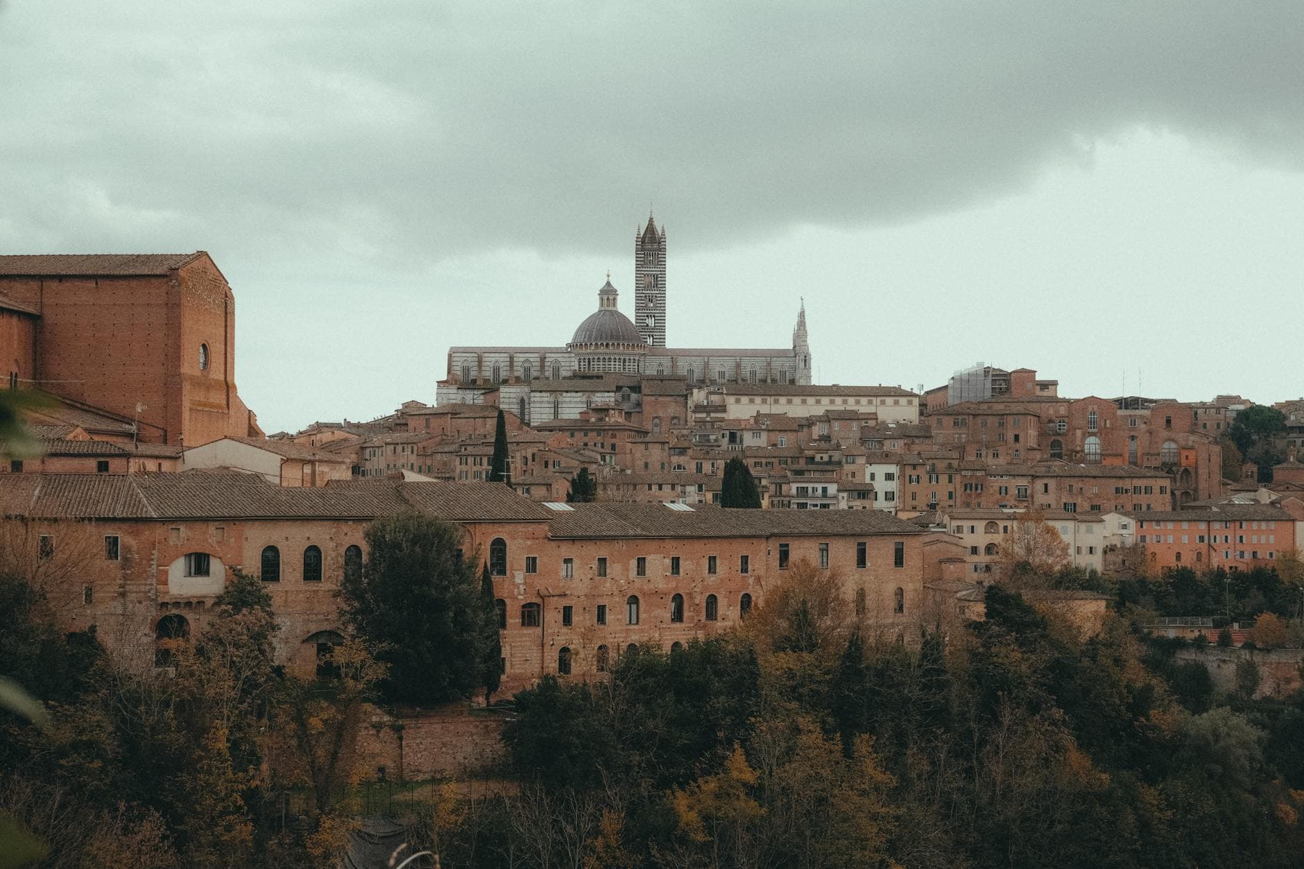 A beautiful, overcast view of Siena, Italy showcasing its iconic medieval architecture and churches.