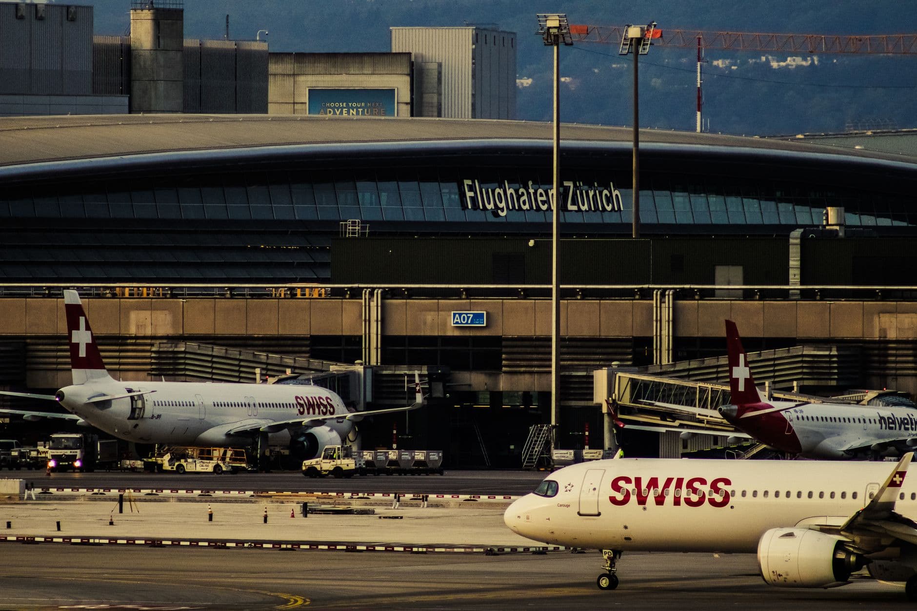 Swiss Airlines planes parked at Zurich Airport with clear view of terminal building.