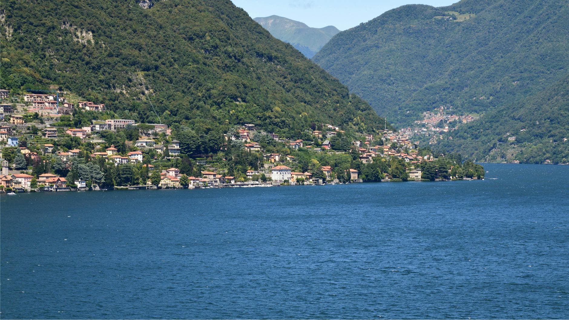 Scenic view of Lake Como with charming hillside villas and lush green mountains.