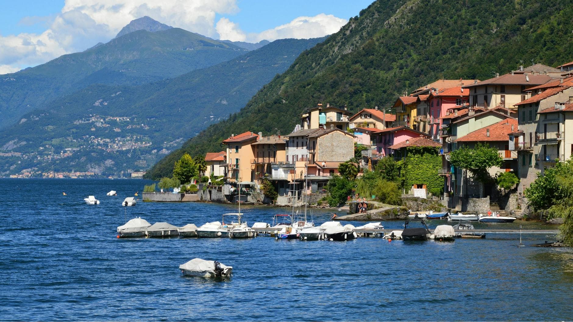 A vibrant view of Lake Como with boats and charming hillside houses.