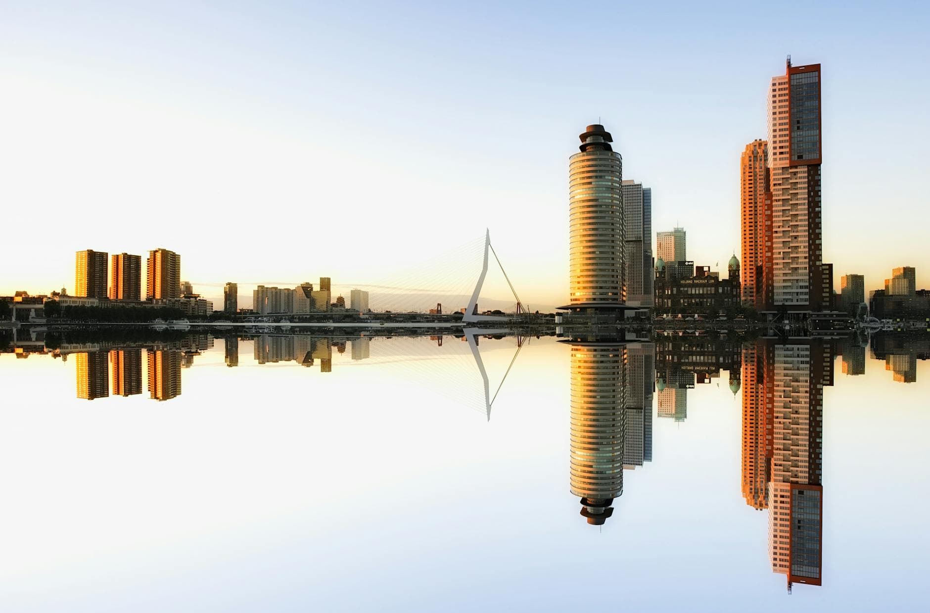 Captivating view of Rotterdam skyline reflecting in water at dusk, showcasing modern architecture.