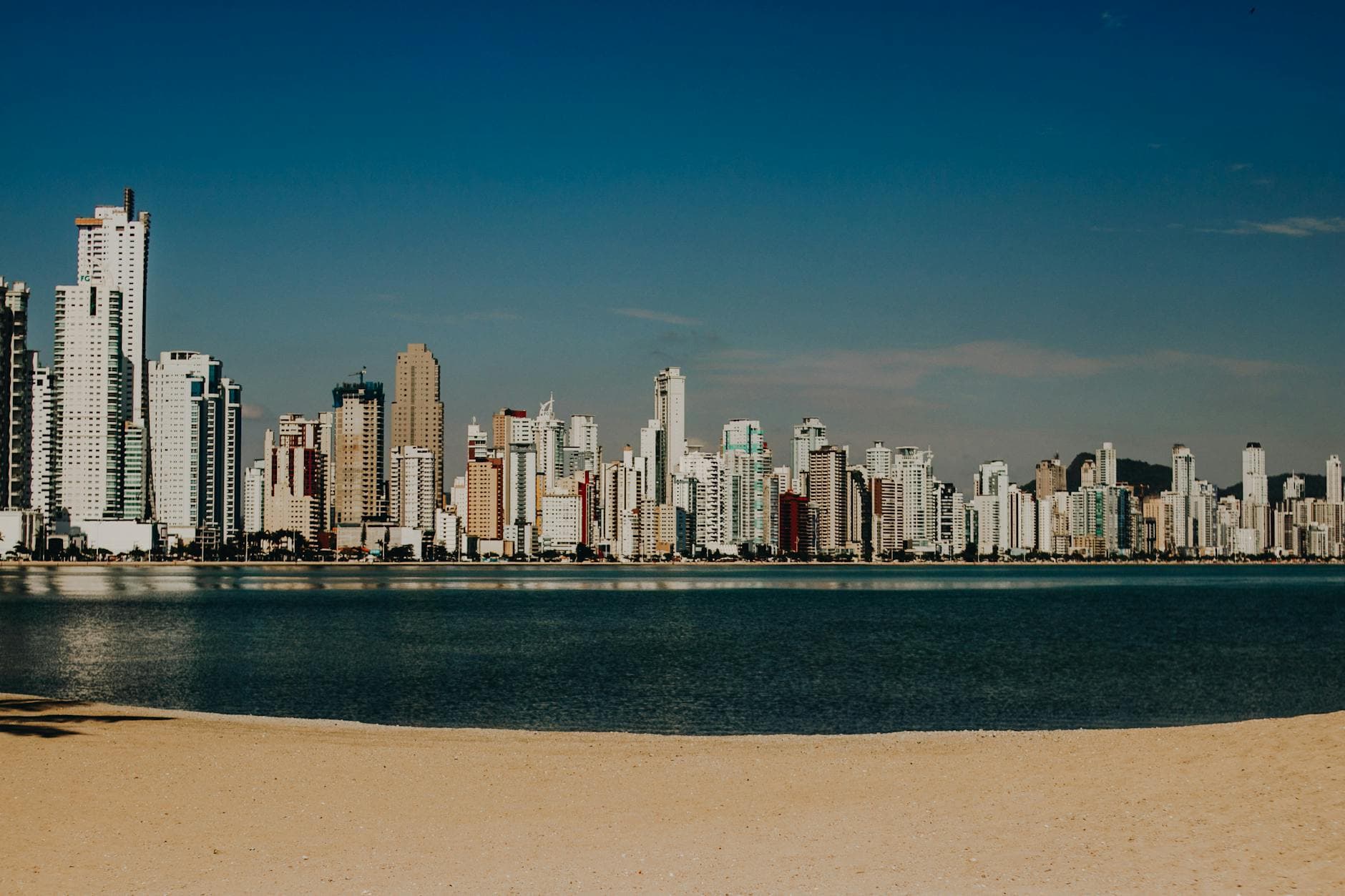 Panoramic view of Balneário Camboriú's skyline with a serene waterfront foreground.