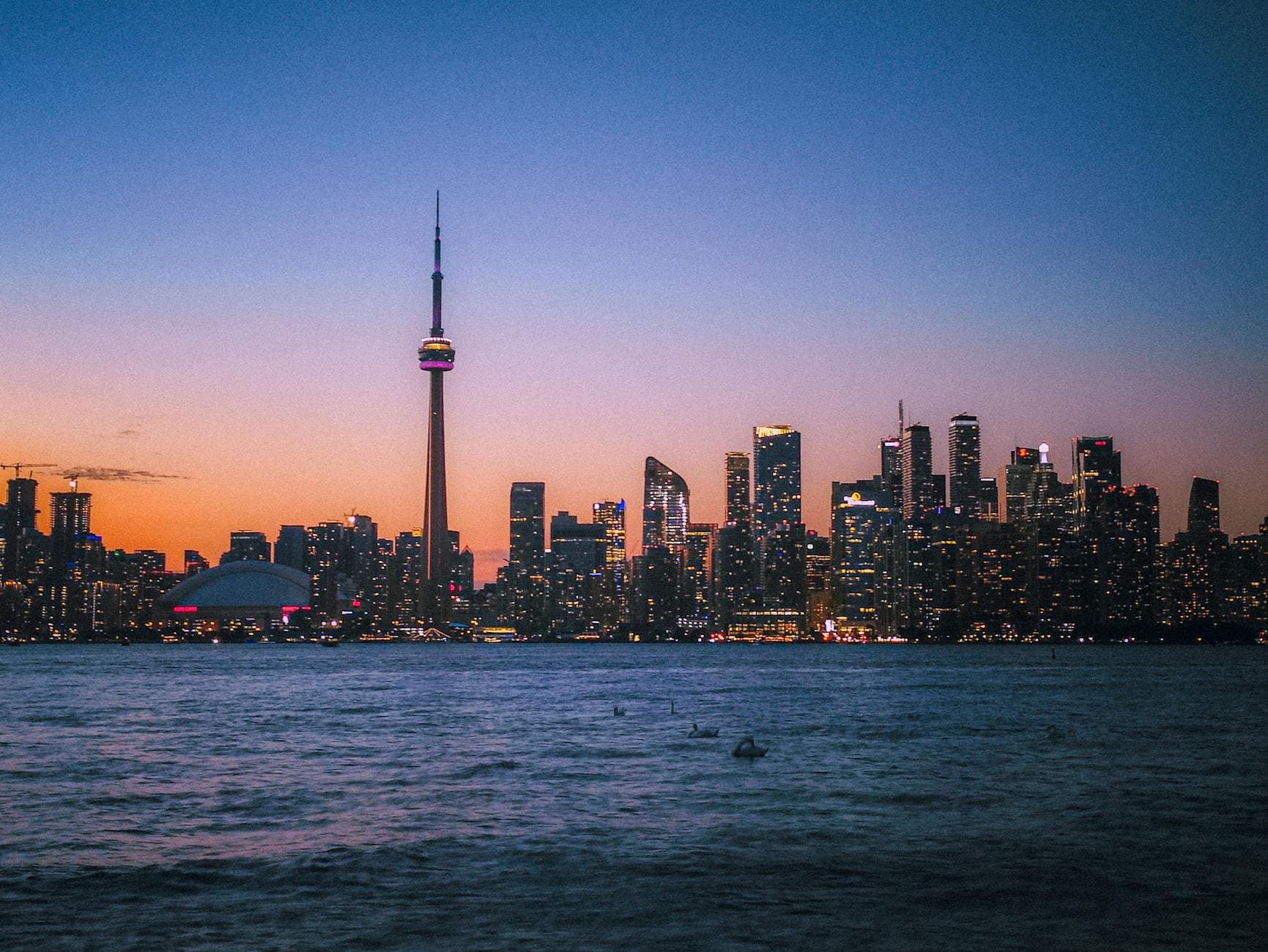 Stunning view of Toronto's modern skyline at twilight featuring the CN Tower and waterfront.