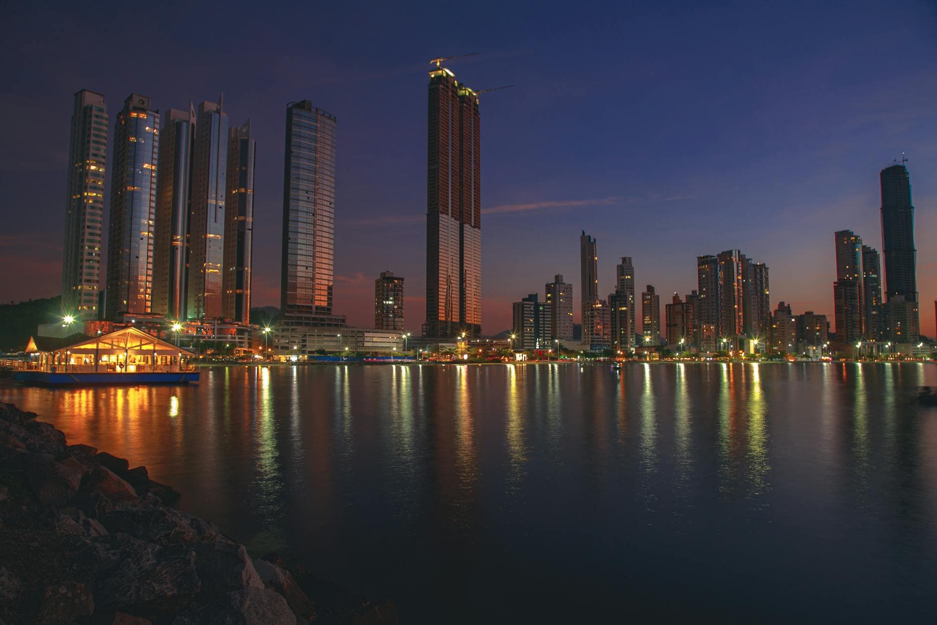 Stunning dusk cityscape of Balneário Camboriú, Brazil with reflections on the waterfront.