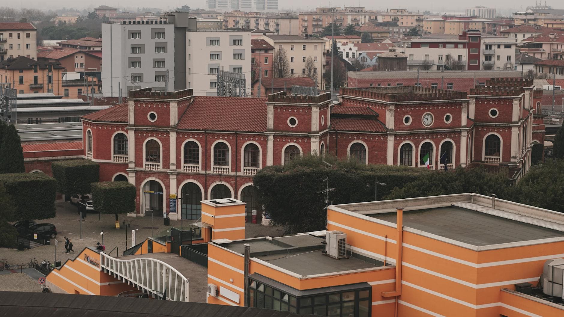 Aerial view of a historic red brick building surrounded by urban architecture in Trezzano sul Naviglio, Italy.