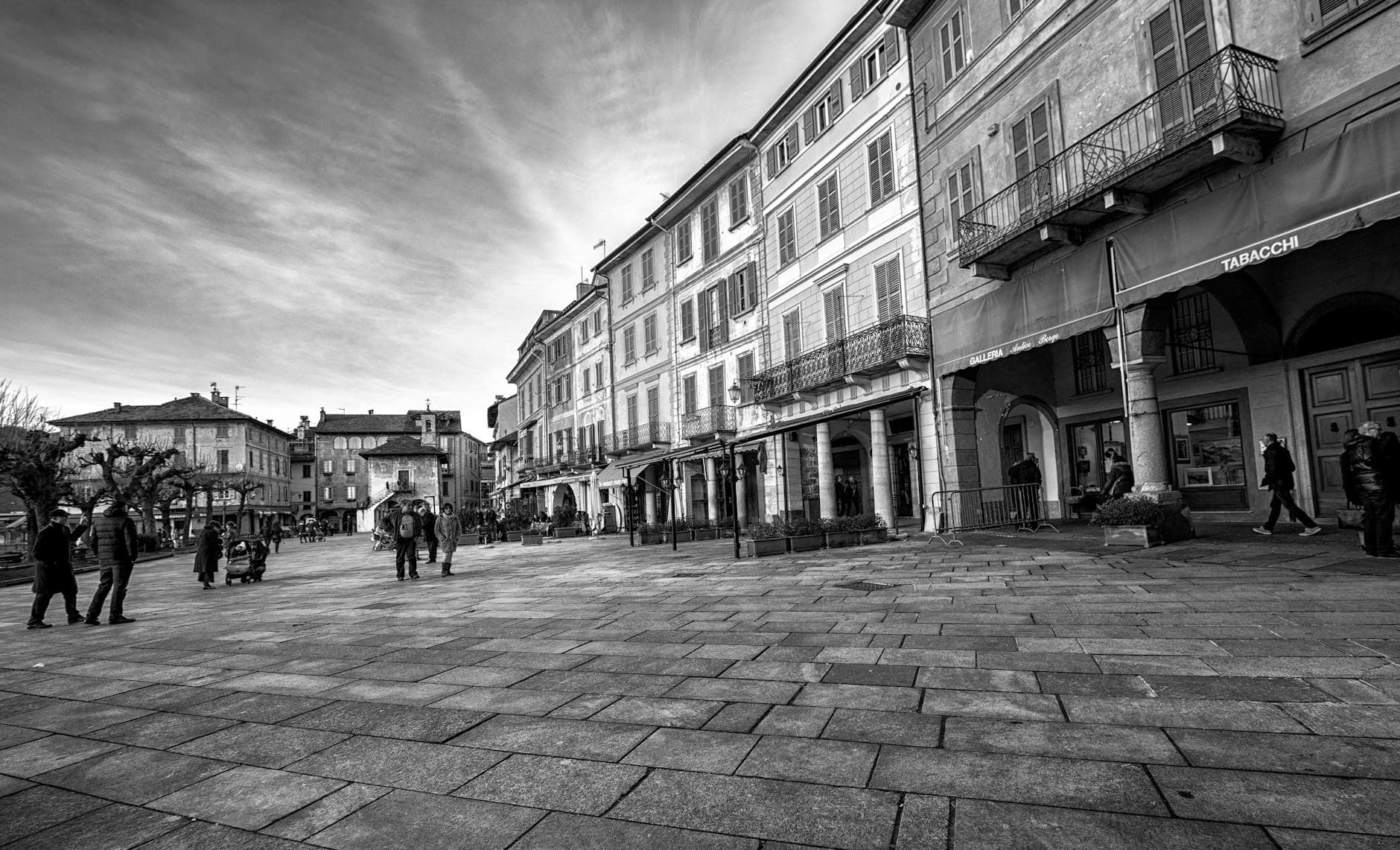 A serene black and white photo of an urban city plaza with historic architecture.