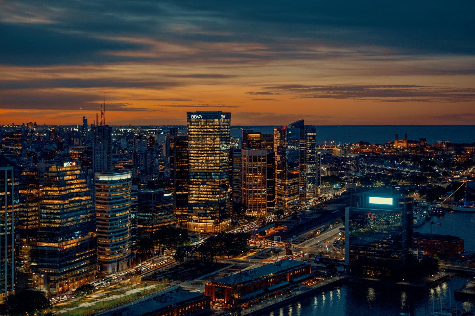 Panoramic night view of Buenos Aires skyline with illuminated skyscrapers and waterfront.