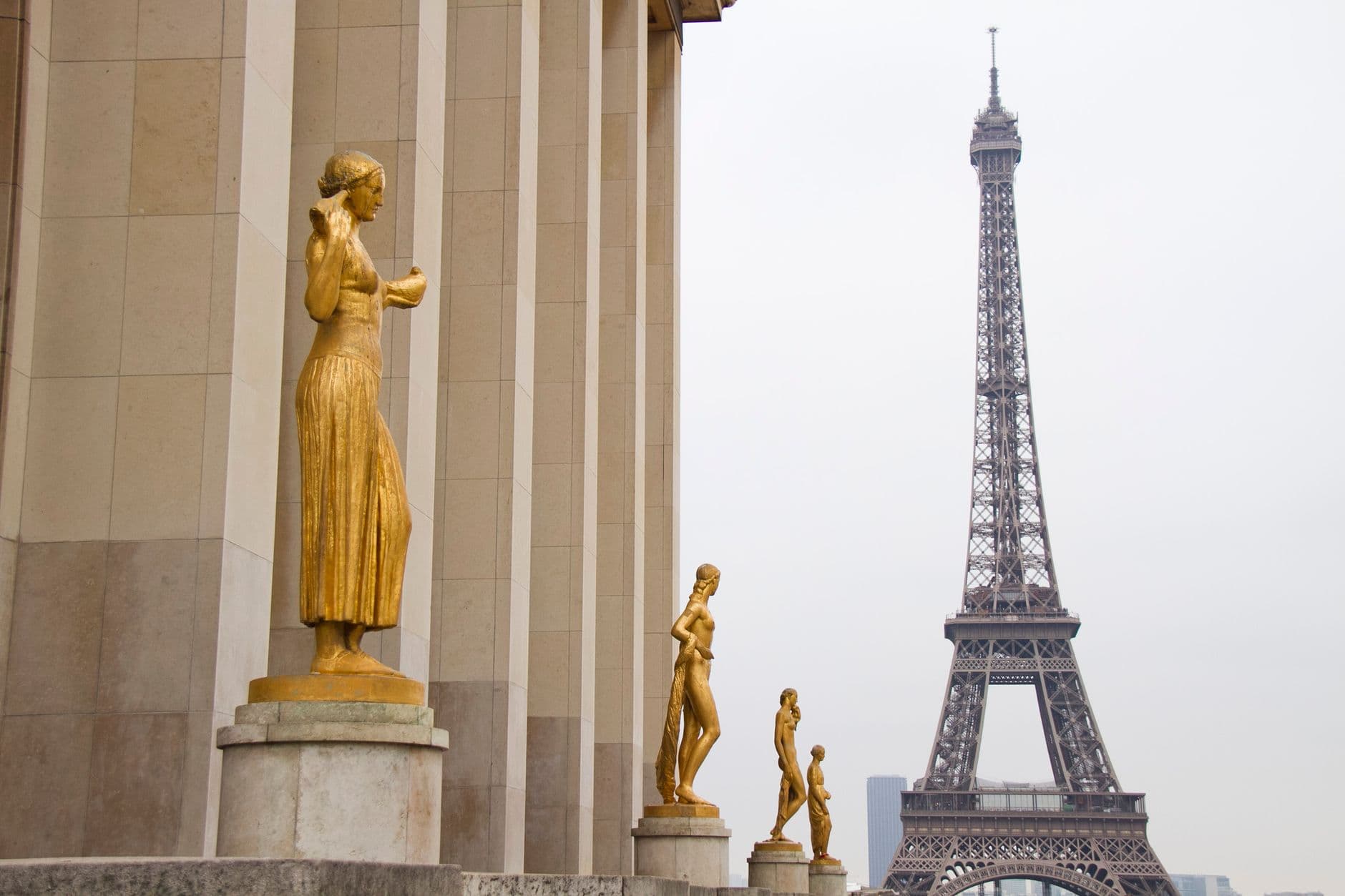 Golden statues at Trocadéro with the iconic Eiffel Tower in view, Paris.