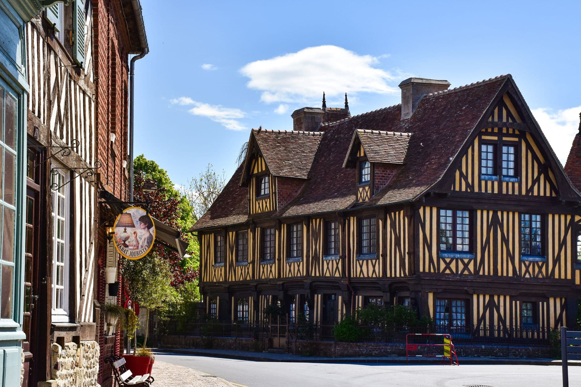 Picturesque street view of traditional half-timbered houses in Normandy, France, on a sunny day.