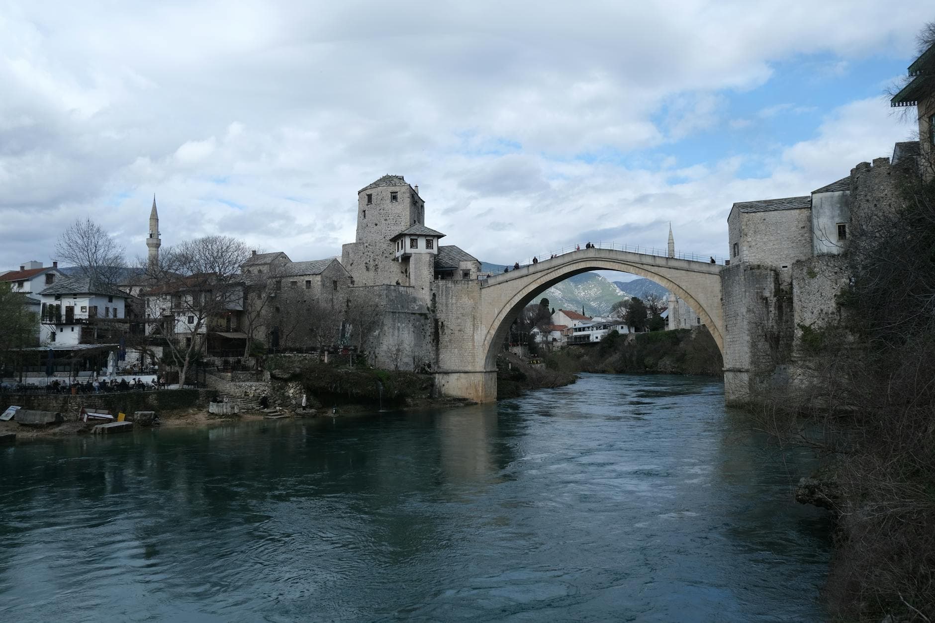 Scenic view of Stari Most in Mostar, Bosnia and Herzegovina, surrounded by historic architecture.
