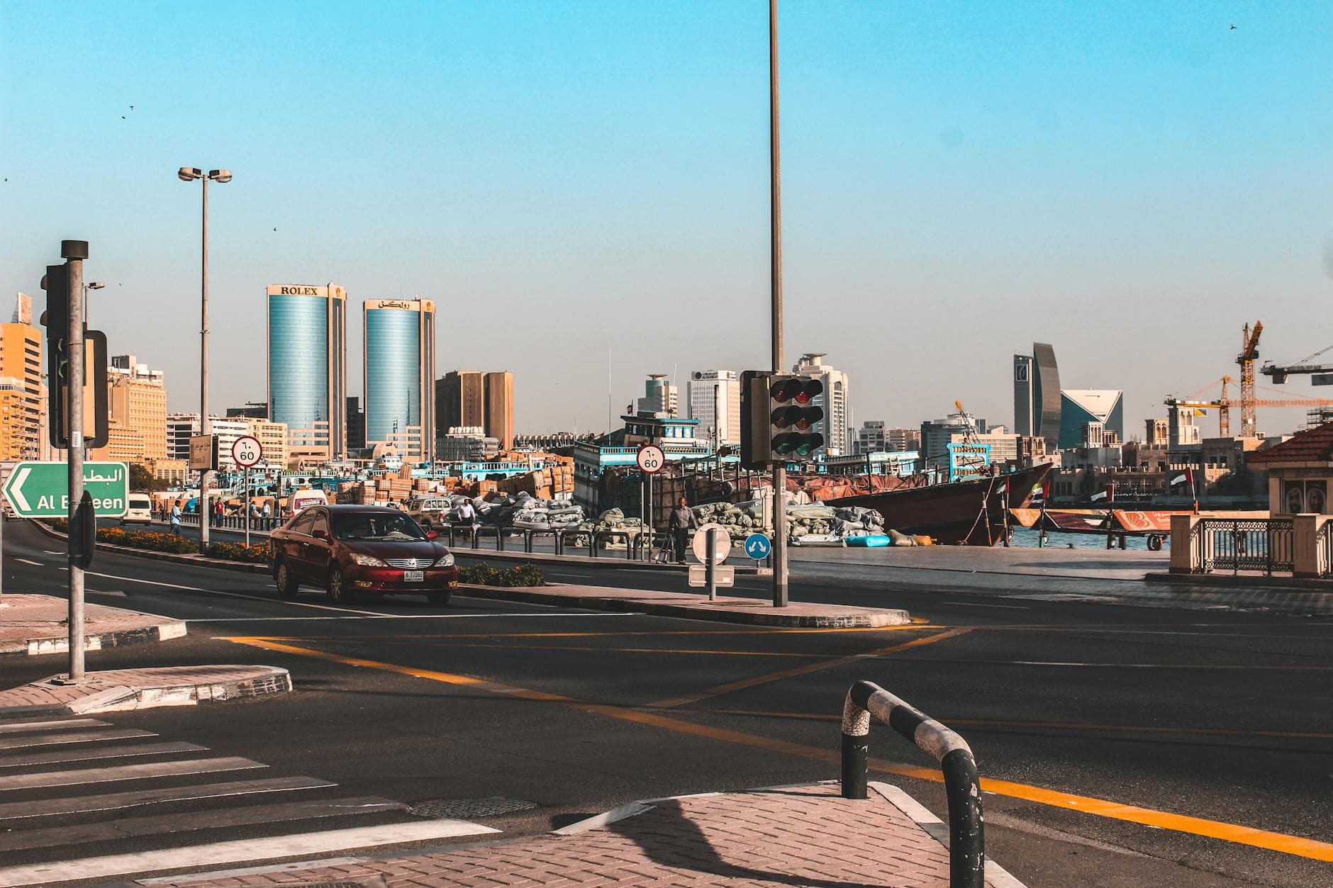 A vibrant street view in Dubai featuring traffic and city skyline with clear skies.