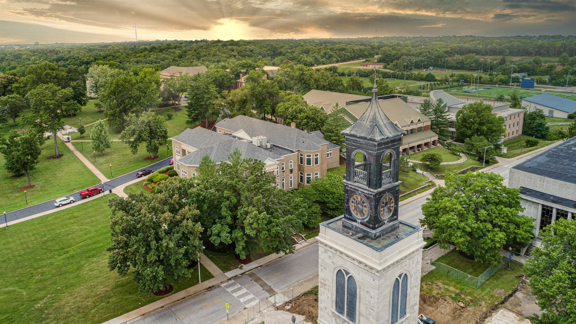 Sunset aerial view showcasing the historic clock tower and lush campus of Westminster College.