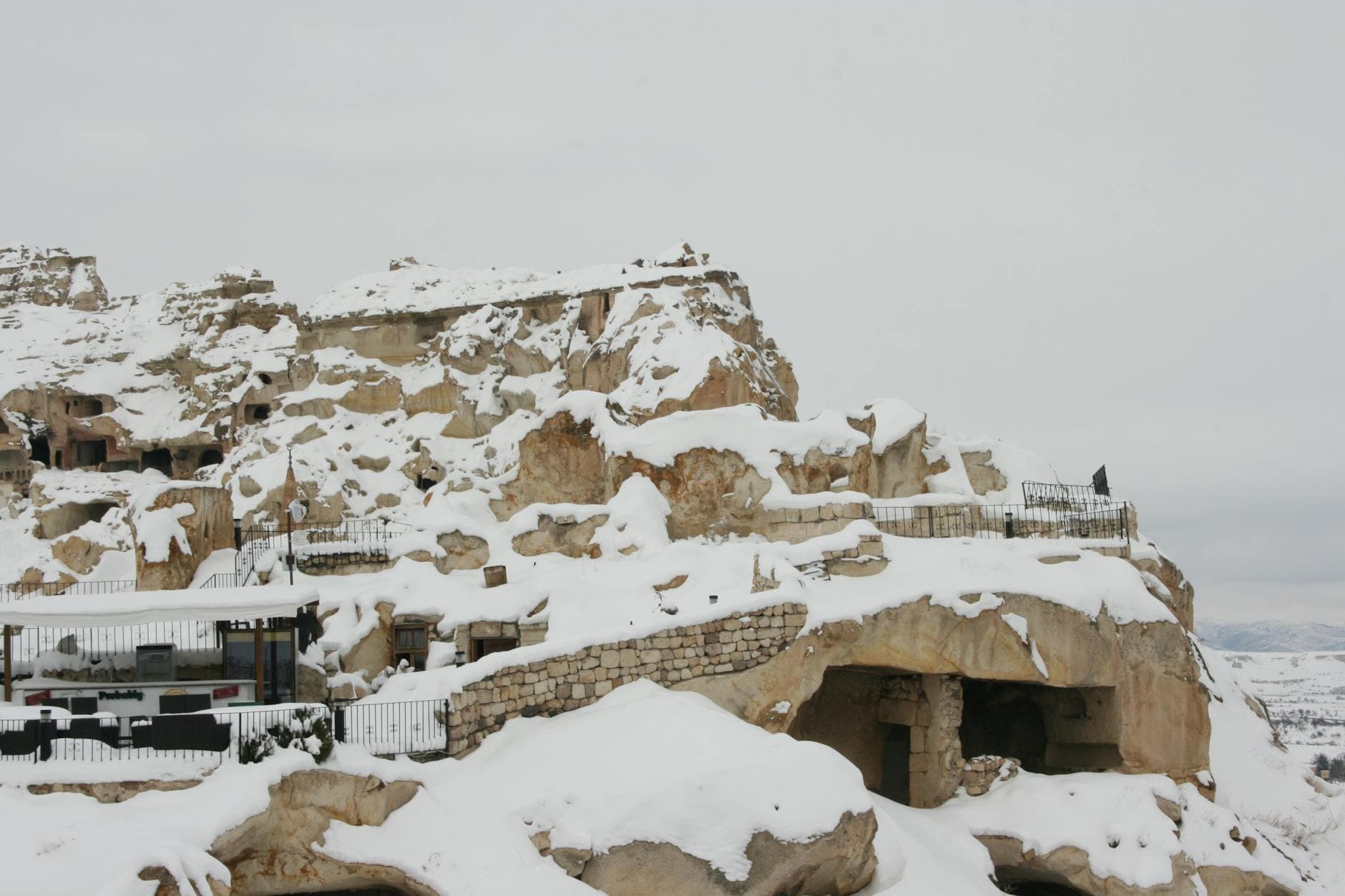 Snowy landscape of historic caves in Ürgüp, Nevşehir, Türkiye during winter.
