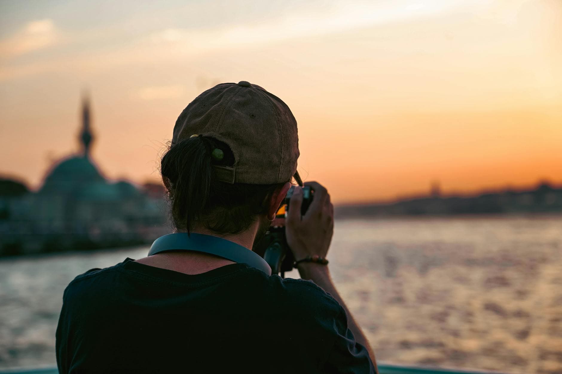 Photographer captures breathtaking Istanbul sunset at Üsküdar seashore, highlighting skyline silhouette.
