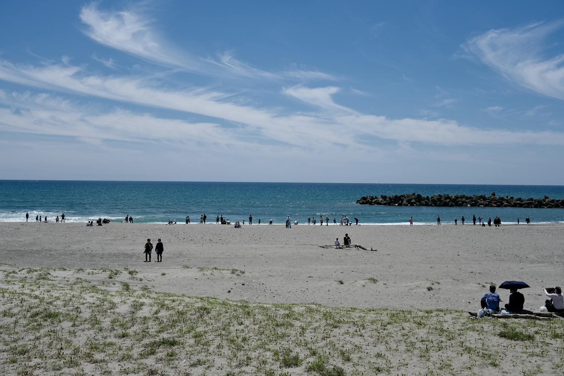 A relaxing scene at Hamamatsu Beach in Shizuoka, Japan, with people enjoying the summer day.