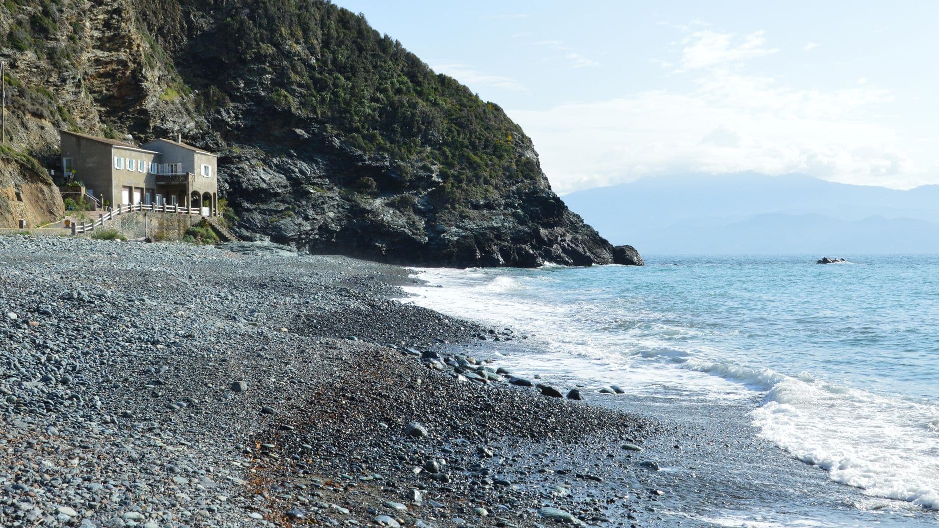 Picturesque rocky coastline in Olmeta-di-Capocorso, Corsica, featuring rugged cliffs and serene sea.