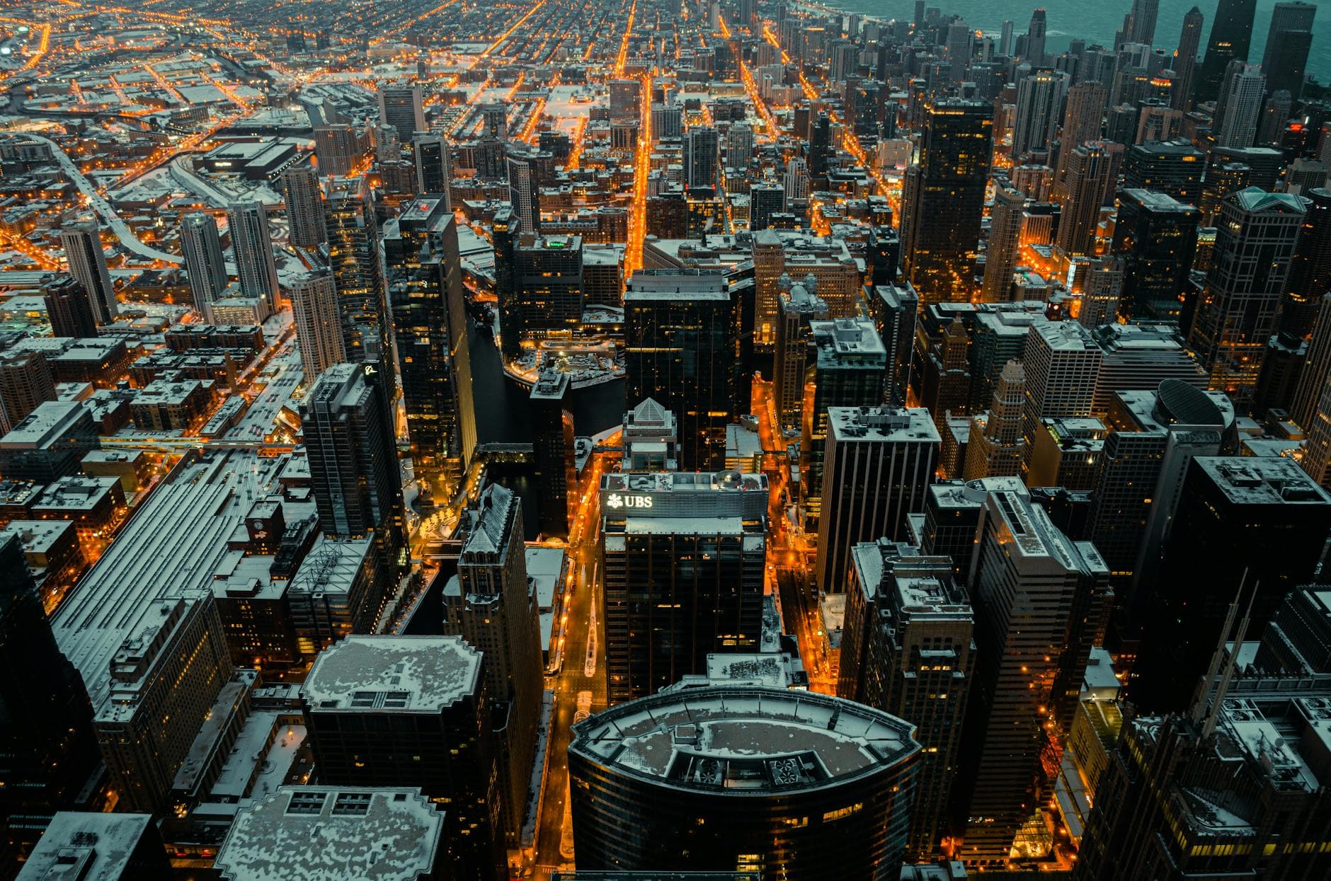 Stunning aerial view of Chicago's illuminated skyline dusted with snow at twilight.