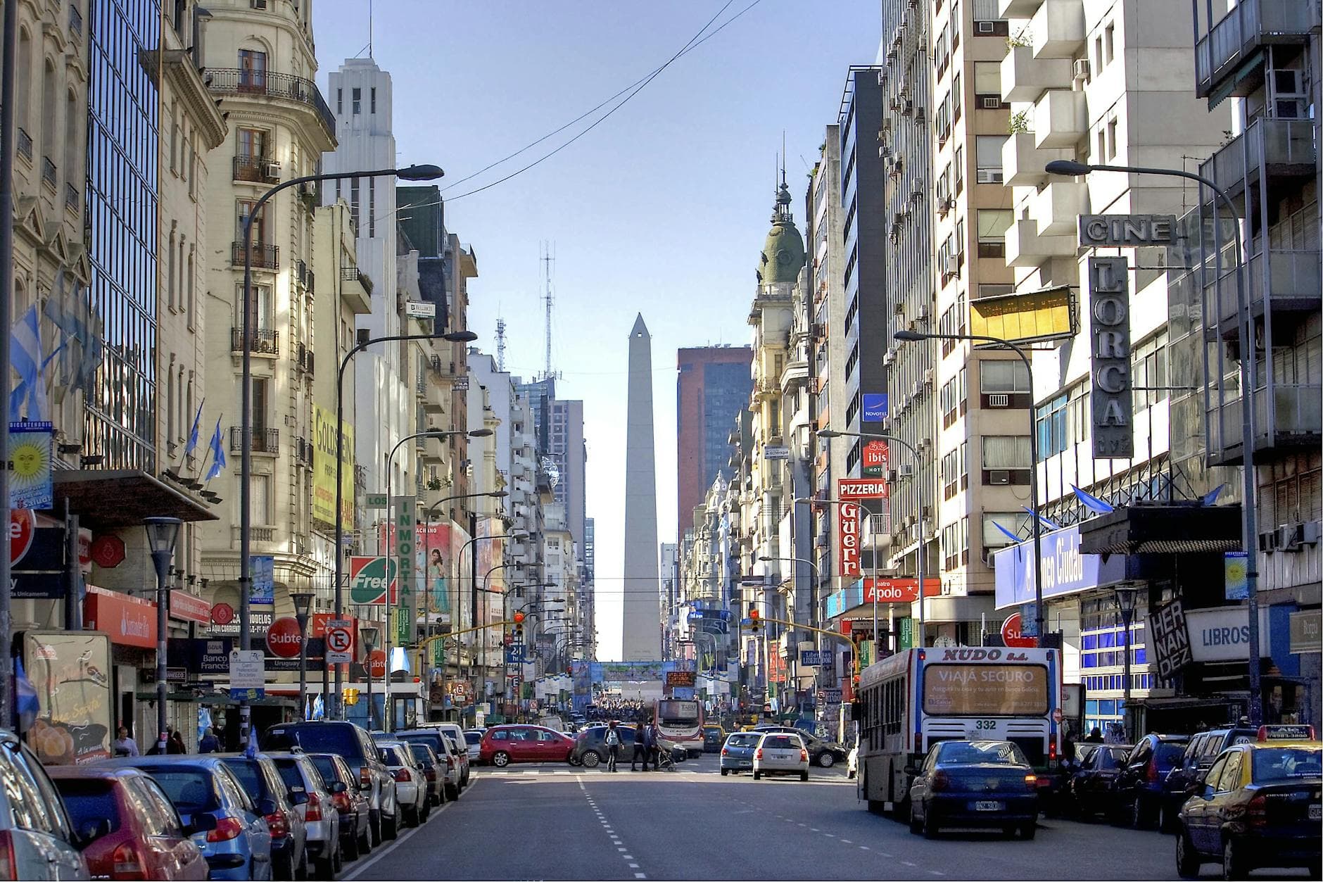 A lively urban scene along Avenida 9 de Julio with impressive skyscrapers and iconic Obelisk.