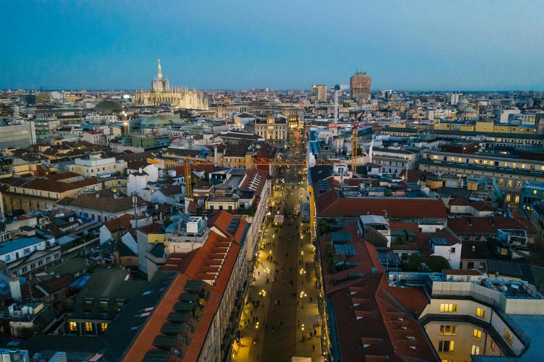 Stunning aerial view of Milan cityscape with illuminated streets and iconic cathedral.