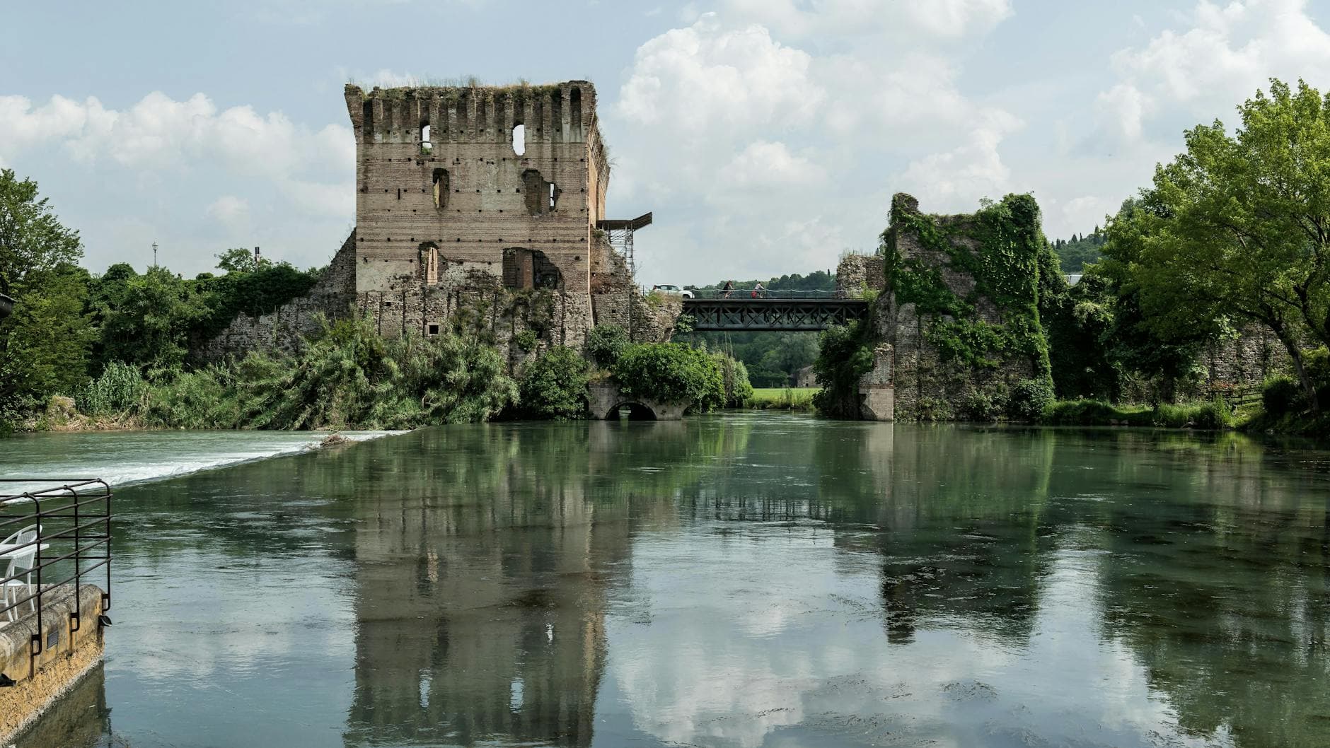 Discover the serene beauty of ancient ruins by the river in Valeggio sul Mincio, Italy.