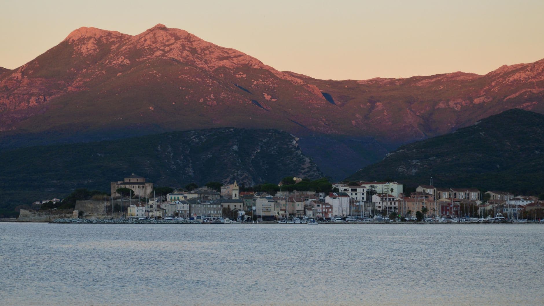 Beautiful sunset over Saint-Florent with mountains and coastline in Corsica, France.