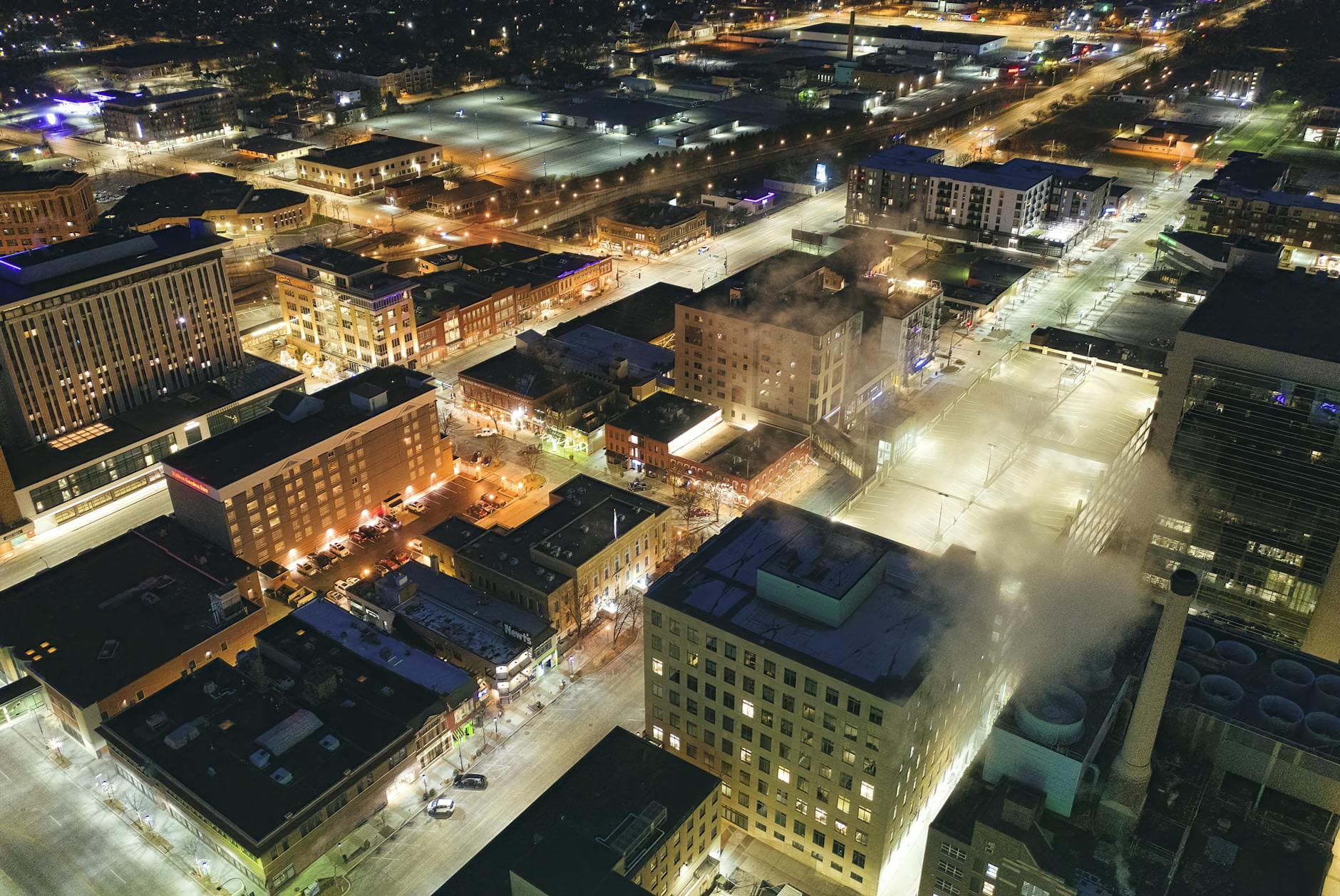 Stunning aerial view of downtown Rochester, MN, illuminated at night with city lights and streets in view.