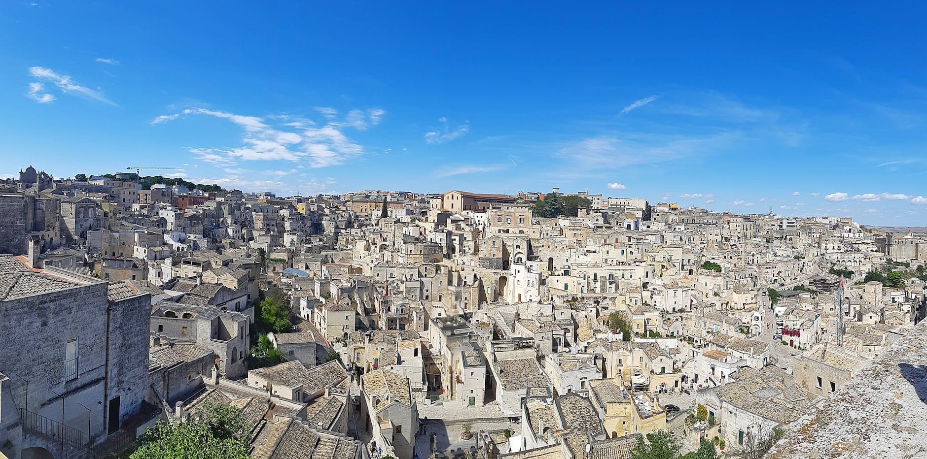 Explore the ancient architecture and breathtaking skyline of Matera, Italy in this vibrant aerial panorama.