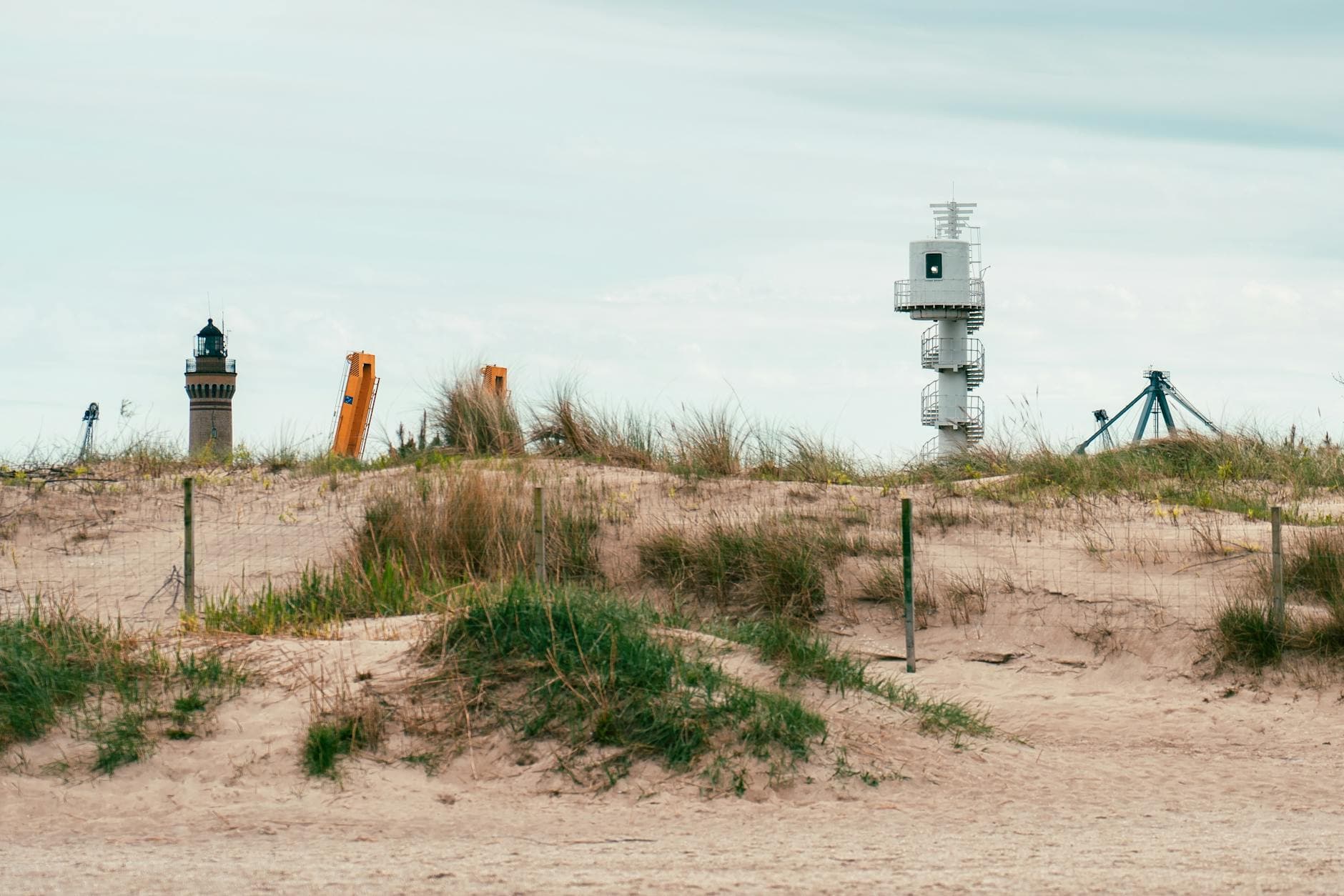 Lighthouses standing behind sand dunes and grass in Świnoujście, Poland.