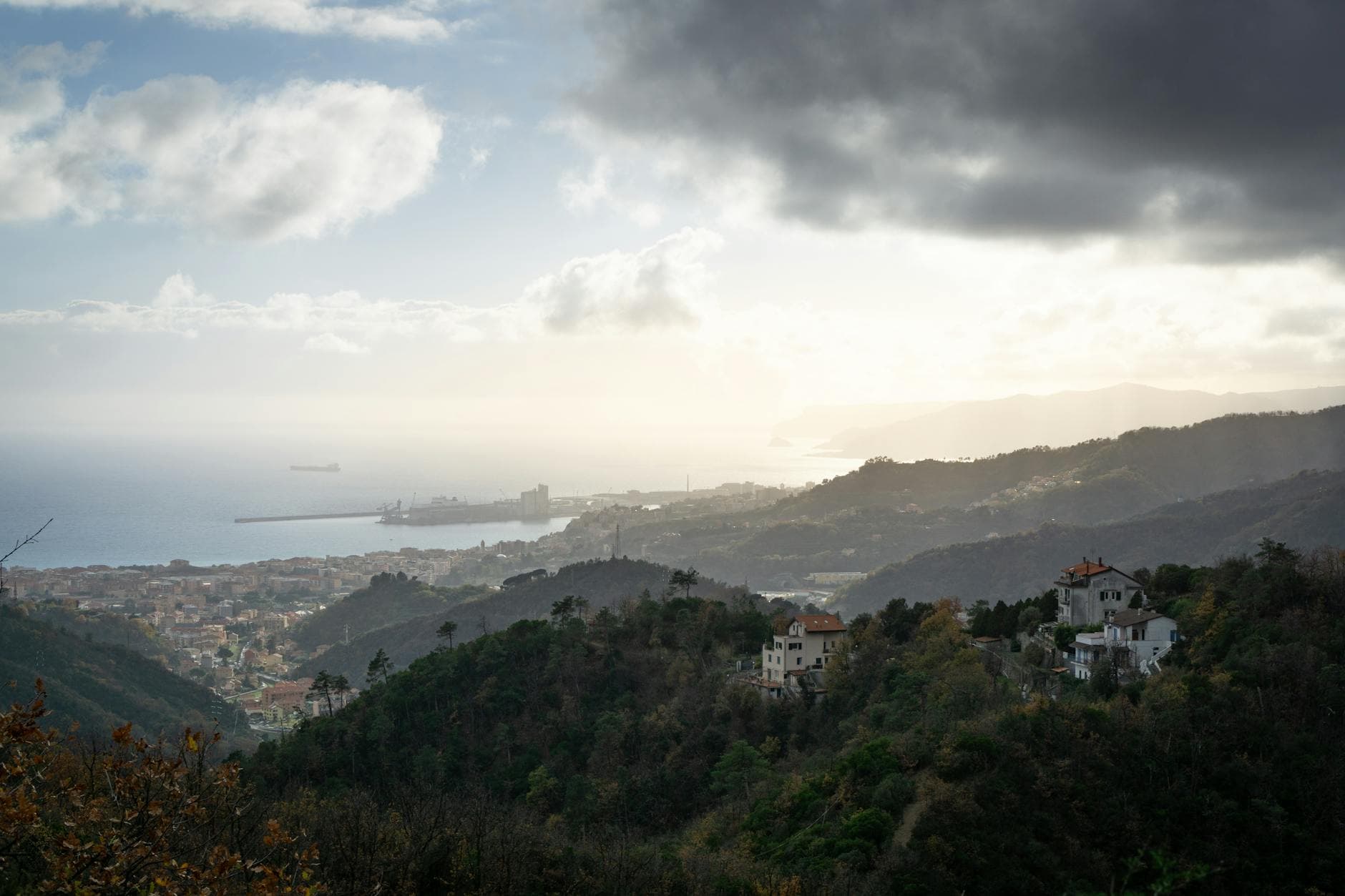 Scenic aerial view of Savona, Liguria coastline with hills and ocean at dusk.