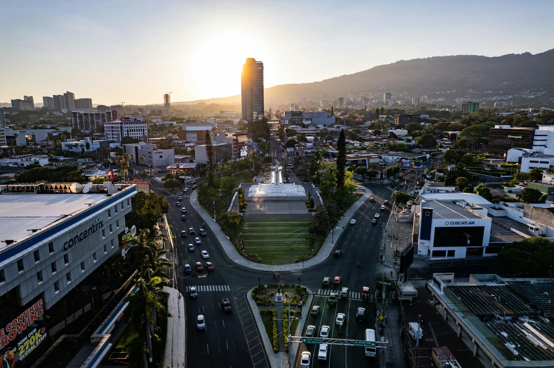 A captivating aerial view of San Salvador at sunrise featuring modern buildings and bustling streets.