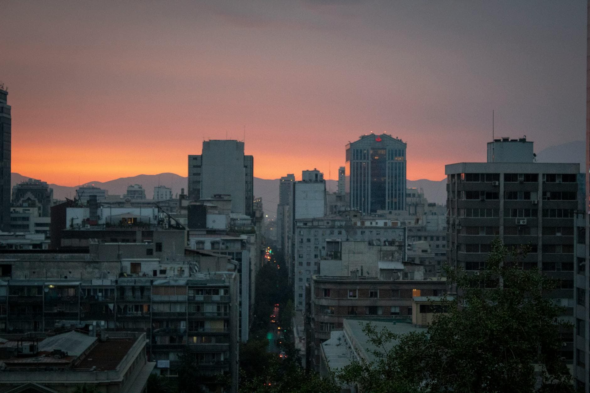 A vibrant city skyline at twilight, showcasing towering skyscrapers against a colorful sunset sky.